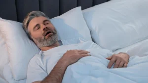 man snoring sleeping in bed